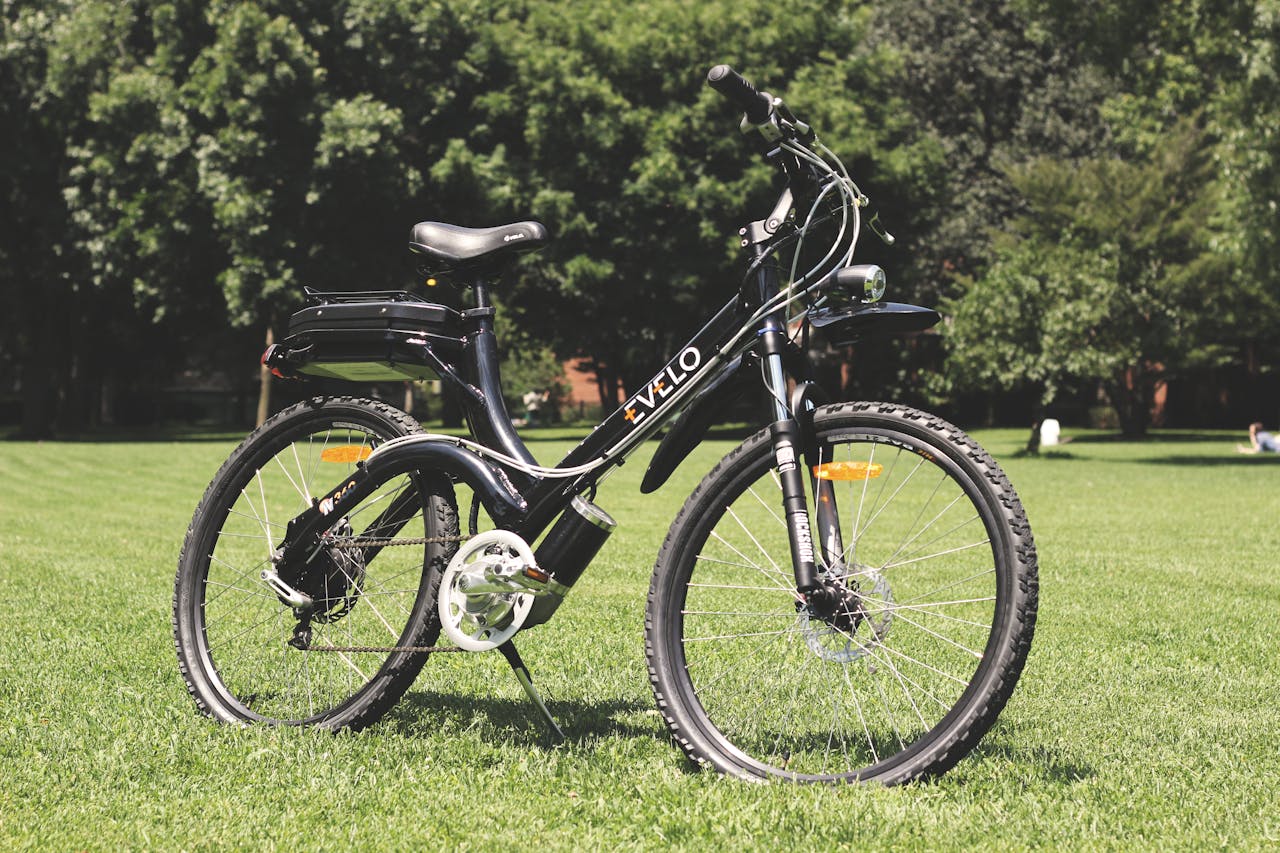 A stylish electric bike parked on lush green grass under the sunny sky.